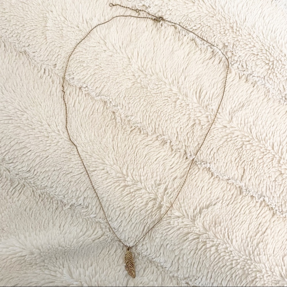 Gold tone necklace with feather pendant